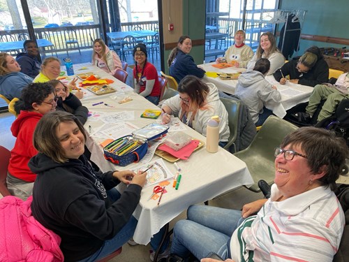 ASB participants on the Life Without Limits experience crafting and coloring with community members at a day camp for adults with disabilities.