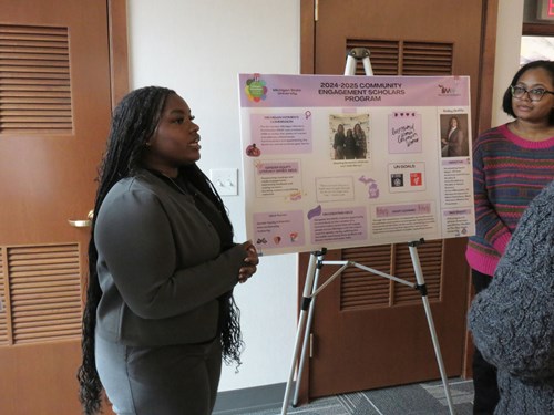 Scholar Bailey Griffin presents a poster on her community engagement with the Michigan Women's Commission.