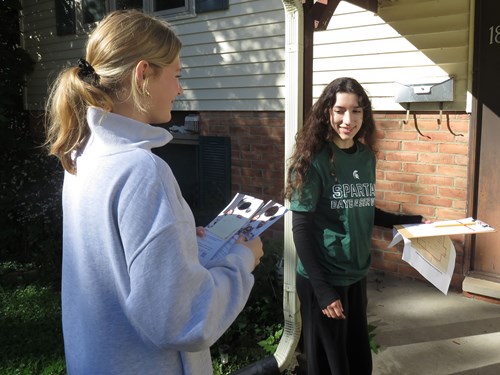 Two Honors College Service Club volunteers handing out pamphlets about the American Red Cross home fire safety program.