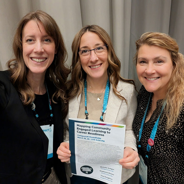 (Left to Right) CCEL assistant directors Stephanie Brewer, Michelle Snitgen, and Tina Houghton with their roundtable handout, titled 'Mapping Community Engaged Learning to Career Readiness,' at the Compact26 conference on March 16, 2026