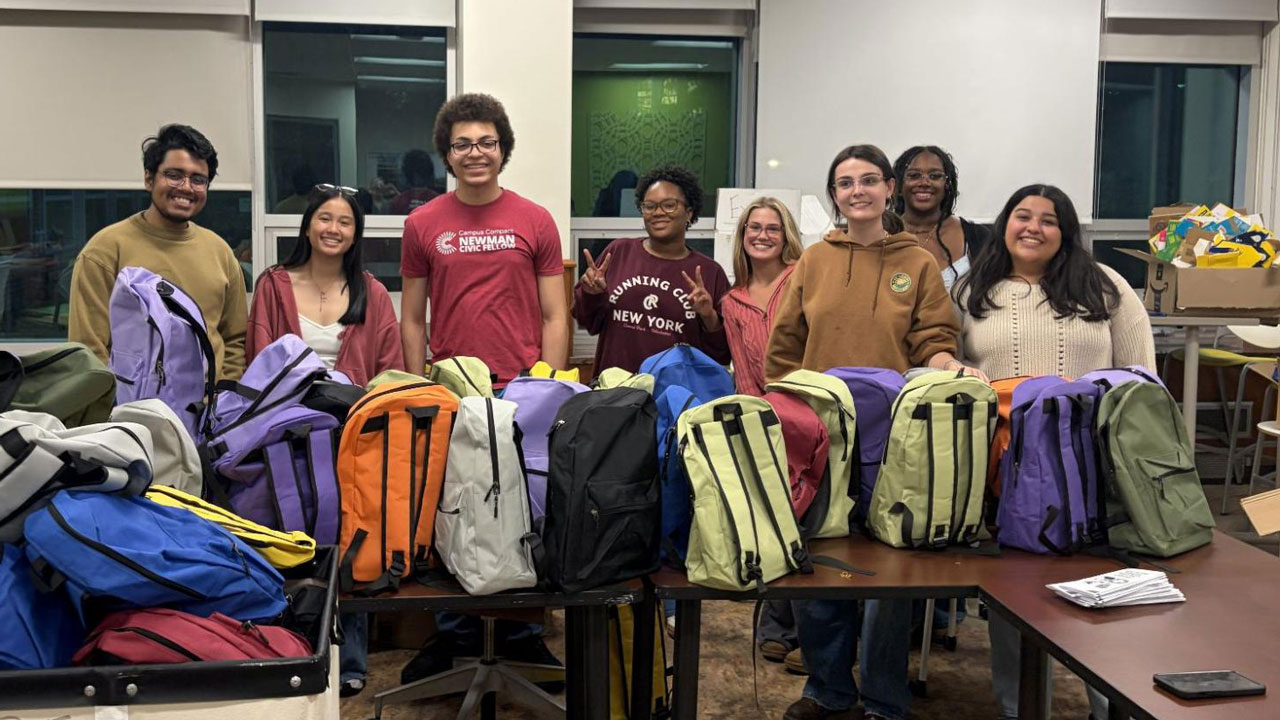 2025-2026 scholars with many of the 100 resource kits they packed for the Tenant Resource Center as their cohort project. Left to Right: Prachurjo Das, Madelyn Schurman, Roberto Marcos Garcia, Deanna Retland, Ainsley McNamara, Abigail Livingston, Kennedy Allen, Anabelle Sanchez