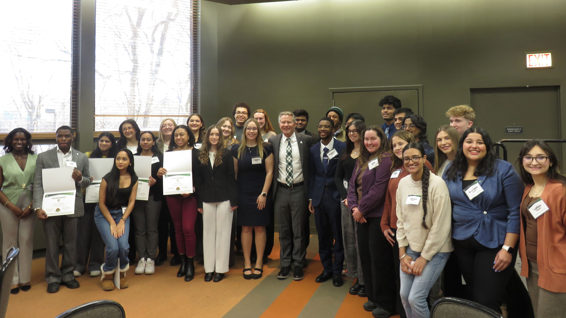 A group photo of Spartan Volunteer Service Awardees in attendance at the ceremony on January 23rd, 2025, with President Kevin M. Guskiewicz (center)