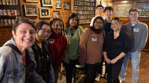 A group selfie of Catharine White (left) and students inside of a Flint restaurant during the scavenger hunt portion of the tour.