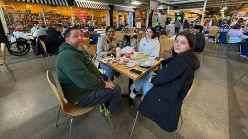 MSU students mingle with community members during lunch at the Flint Farmers Market.